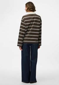 Bruin en crème gestreepte lange mouwen shirt met een kraag, gecombineerd met wijde denim jeans. Zachte stof textuur, casual pasvorm.