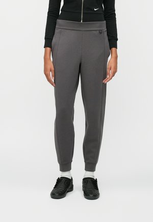 Szürke, szűkített szabású melegítőnadrág, gumis derékkal és oldalsó csíkokkal. Anyaga texturált, a derékon pedig diszkrét logó található.