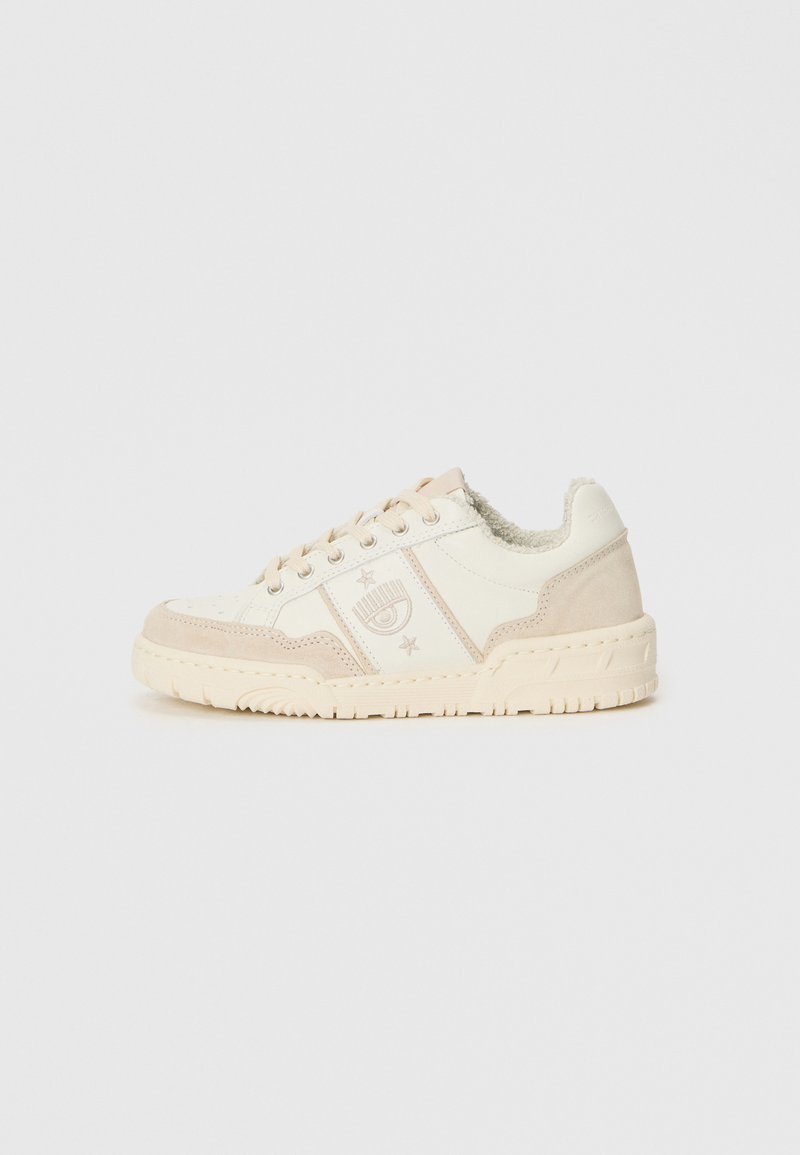 Zapatilla beige y crema con parte superior de ante y cuero, acentos texturizados, suela con estampado y logotipo decorativo en el costado.