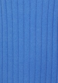 Tissu tricoté bleu avec une texture côtelée verticale. Les coutures régulières sont bien visibles, créant une apparence lisse sur tout le matériau.