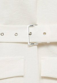 Weißer Stoffgürtel mit einer silbernen rechteckigen Schnalle, die mit Metallösen entlang des Riemens versehen ist. Glatte Textur, flaches und breites Design.