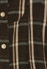 Brun ternet stof med vekslende creme- og grå striber. Har en tekstureret vævning og en synlig gylden knapdetalje.