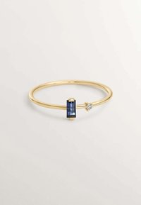 Anillo de oro con una piedra preciosa azul rectangular y un pequeño diamante como acento, con una superficie lisa y pulida y un diseño de banda delgada.