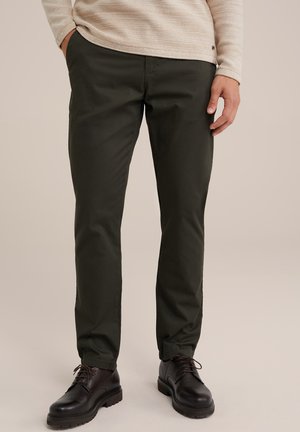 Donkergroene katoenen broeken met een slim fit, voorzien van zijzakken en een gladde textuur, gecombineerd met bruine leren schoenen.