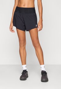 Μαύρο αθλητικό σορτς με φαρδιά ζώνη μέσης, διακοσμημένο με λογότυπο στο αριστερό πόδι και κατασκευασμένο από ελαφρύ, διαπνέον ύφασμα. Καθημερινό σχέδιο, μήκος μέχρι το μέσο του μηρού.