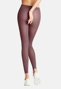 Leggings opachi color malva con vita alta, texture liscia e design aderente, abbinati a scarpe bianche slip-on.