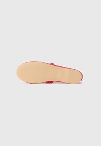 Sandalia roja con un upper texturizado y tejido y una suela de goma suave y de color claro. Cuenta con una correa ajustable para un ajuste seguro.