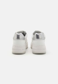 Vita sneakers med glänsande silverdetaljer, en texturerad sula och en upphöjd häl. Har präglad logotyp på sidan. Slät lädermaterial.