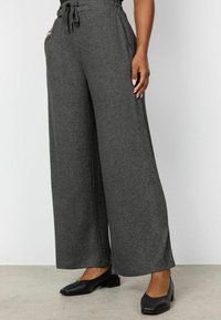 Grijze wijde broek met een drawstring taille, gemaakt van zachte stof, met zijzakken en een gladde textuur, gecombineerd met zwarte flats.