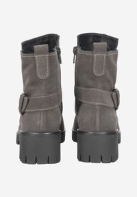 Bottines en suede gris avec un talon noir épais, ornées de sangles décoratives et de fermetures éclair à l'arrière. Détails de couture visibles.