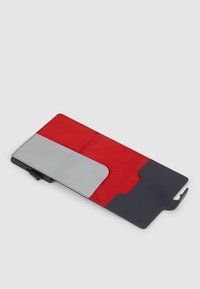 Rood- en grijs telefoonscherm met een gestructureerd oppervlak, voorzien van een magnetische sluiting, contrasterende kleurvlakken en een slank zwart onderstuk.