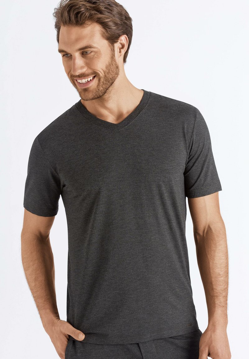 Ciemnoszara, krótko rękawowa koszulka V-neck z gładkiego materiału. Charakteryzuje się luźnym krojem i minimalistycznymi detalami, idealna na co dzień.