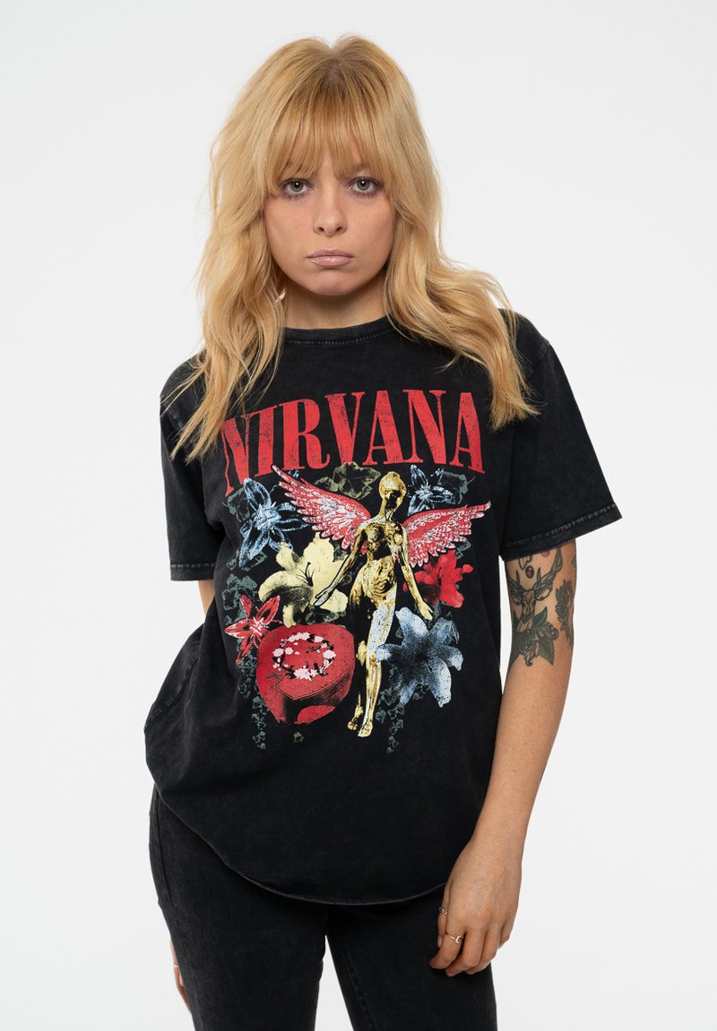 Black cotton T-shirt featuring a colorful "NIRVANA" graphic with a gold figure, flowers, and bold red elements. Short sleeves and relaxed fit.