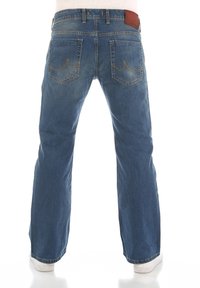 Vaqueros de mezclilla azul con un corte recto, cinco bolsillos, costuras amarillas y una etiqueta de cintura de cuero marrón. La tela parece ligeramente desgastada.