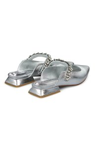 Zilveren metallic muiltjes met een lage vierkante hak, voorzien van een decoratieve band versierd met heldere kristallen en een open achterkant.
