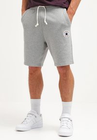 Shorts de mezcla de algodón grises con cintura elástica y cordón, que cuentan con bolsillos laterales y un logo circular de "Converse All Star".