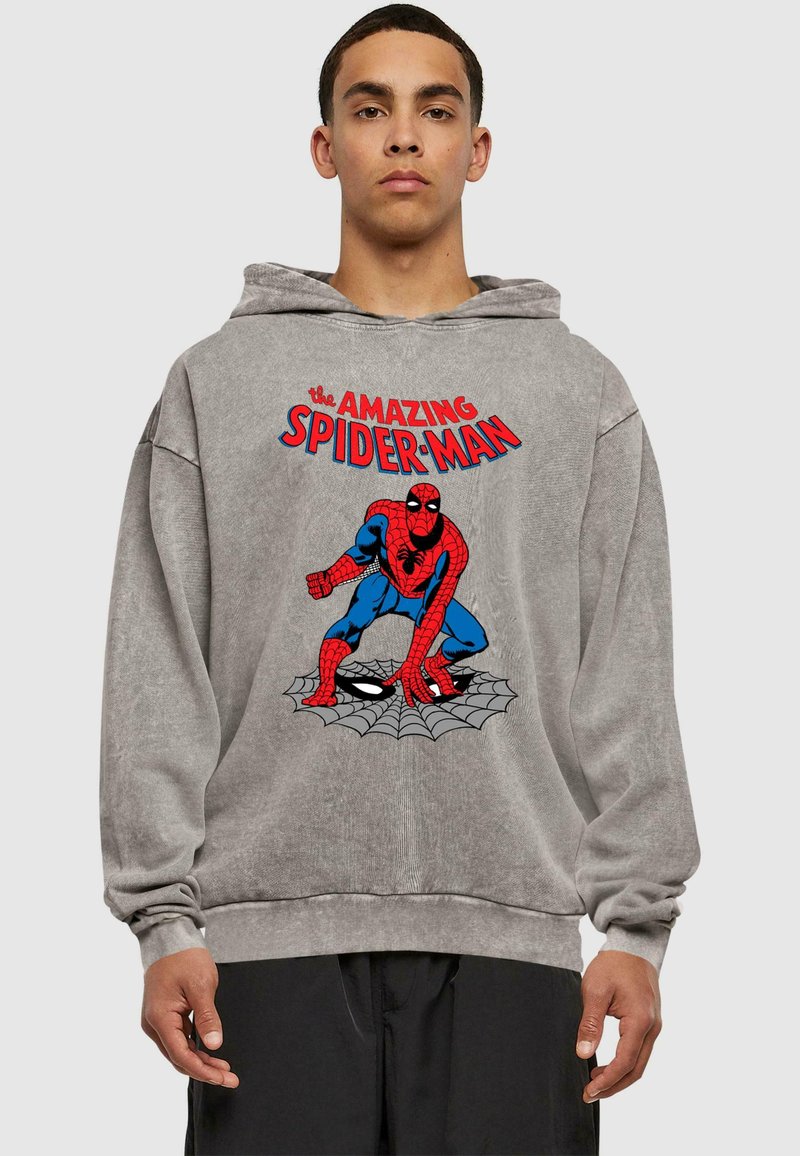 Szürke kapucnis pulóver, amelyen egy nagy, piros és kék Spider-Man grafika látható, a kép felett pedig a "The Amazing Spider-Man" felirat olvasható. Puha tapintású.