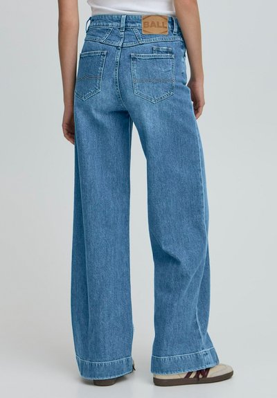 Svetlomodré džínsy s širokými nohavicami vyrobené z denimu, s vysokým pásom, zadnými vreckami a hnedou koženou nášivkou na páse.