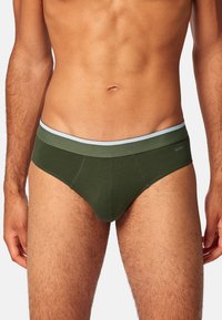 Groene katoenen slipjes met een lichtblauwe elastische tailleband. Het ontwerp is aansluitend met een vormgegeven voorkant voor ondersteuning en een gladde textuur.