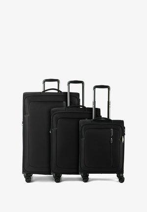 Tre valigie morbide nere con manici telescopici estesi e quattro ruote rotanti, disposte dalla più grande alla più piccola.