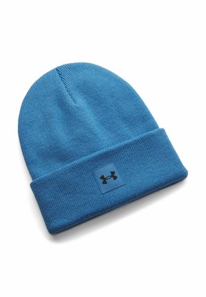 Blue knit beanie with a folded brim, featuring a black Under Armour logo patch on the front, displayed on a white background.