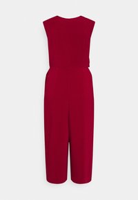Combinaison bordeaux avec un corsage ajusté, des jambes larges et des manches courtes. Elle présente une texture lisse et une fermeture éclair dissimulée dans le dos.