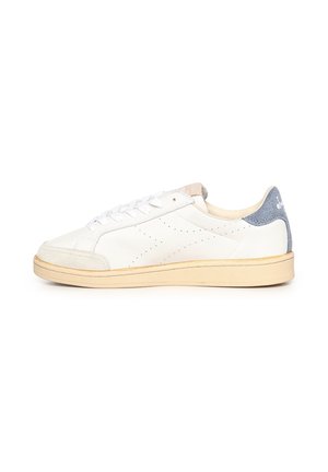 Sneaker bianco basso con suola beige, lacci bianchi, puntale grigio chiaro e toppa in camoscio blu sul tallone con dettaglio logo.