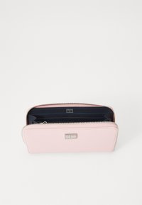 Portafoglio in pelle rosa chiaro con chiusura a zip, dotato di interno blu navy e diversi slot per carte. Piccolo logo argentato sulla parte anteriore.