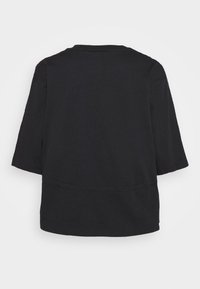 Camiseta negra de manga corta y cuello redondo mostrada desde atrás sobre un fondo blanco liso.