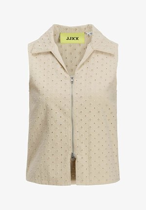 Bež top brez rokavov z zadrgo spredaj, ki ima teksturno vzorčenje majhnih cvetličnih motivov in usnjen ovratnik. Oznaka blagovne znamke je vidna znotraj.