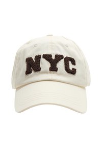 Béžová basebalová šiltovka s vypuklými tmavo-hnedými chlpatými písmenami "NYC" na prednom paneli.