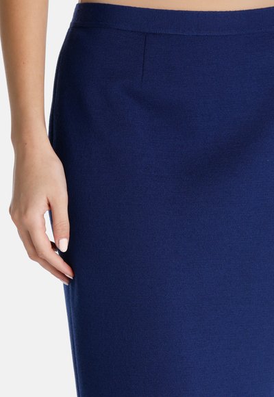 Jupe en tricot bleu marine, longueur genou, avec une texture lisse, dotée d'une taille étroite et d'un design épuré sans fermetures ni motifs visibles.