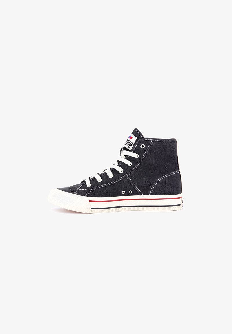 Baskets montantes en toile noire avec semelle en caoutchouc blanche, lacets blancs, bande rouge sur la semelle, et patch logo de la marque sur la languette.