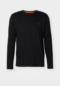 Black long-sleeve t-shirt made of cotton, featuring a round neckline, a small black logo patch on the chest, and an orange inner collar.