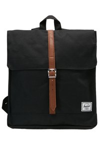 Sac à dos carré noir avec une sangle à boucle marron et une petite étiquette de marque blanche en bas à droite.