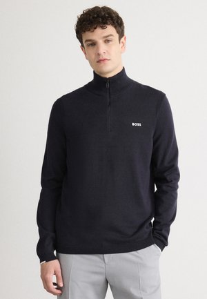 Dunkelblauem Pullunder mit Reißverschluss aus weichem Stoff, mit gerippten Bündchen und Saum. Mit kleinem weißen "BOSS"-Logo auf der linken Brust.
