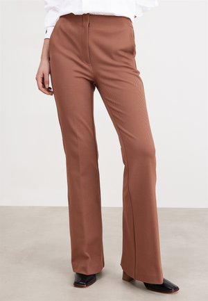Pantaloni maronii, texturati, cu un design drept, având un brâu neted și plii subtile. Asortați cu pantofi negri cu toc.