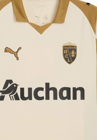 Cremfarbene Jersey mit goldenen Akzenten, V-Ausschnitt, Puma-Logo und dem Emblem des Racing Club de Lens. Unter dem Logo prangt der große schwarze Schriftzug "Auchan".