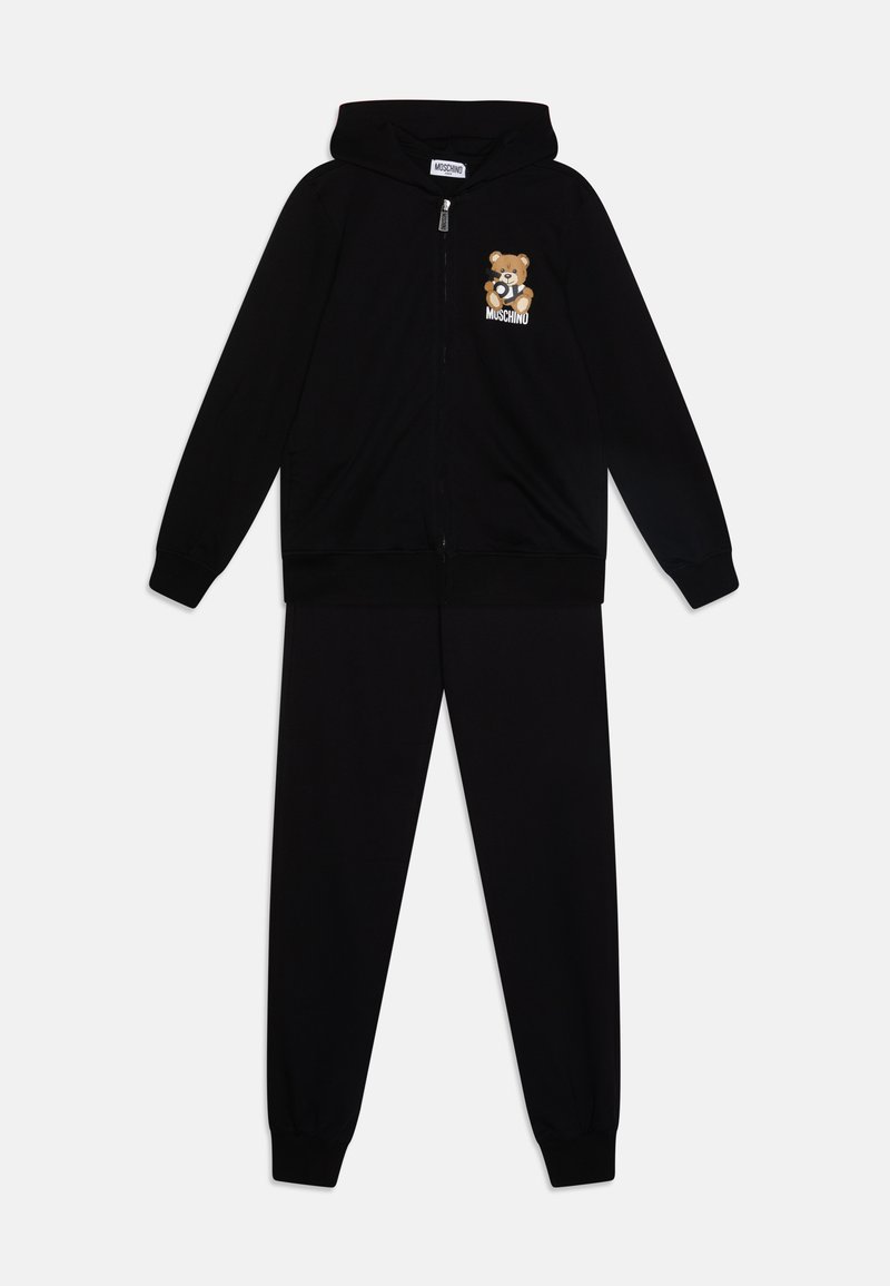 Melna kapučjaka ar rāvējslēdzēju un biksēm, kas izgatavotas no mīkstas auduma, ar lāča grafiku kreisajā krūšu daļā. Elastīgas aproces un josta.