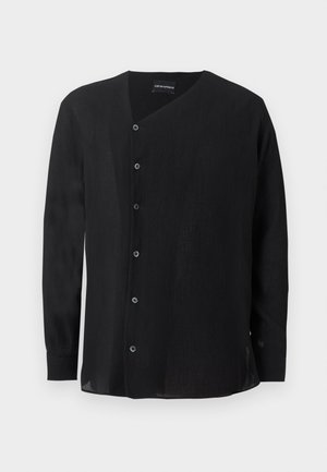 Μαύρο πουκάμισο με μακριά μανίκια από υφασμάτινη υφή, ασύμμετρο κλείσιμο με κουμπιά και γιακά V-neck σε απλό λευκό φόντο.