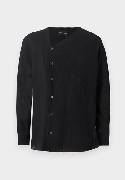 Μαύρο πουκάμισο με μακριά μανίκια από υφασμάτινη υφή, ασύμμετρο κλείσιμο με κουμπιά και γιακά V-neck σε απλό λευκό φόντο.