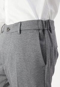 Szare, teksturowane spodnie z elastyczną talią, przednimi kieszeniami, zapięciem na guzik i gładkim wykończeniem materiału. Odpowiednie zarówno na co dzień, jak i na formalne okazje.