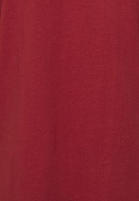 Roter Baumwollstoff mit glatter Textur. Die Oberfläche ist einfarbig ohne Muster oder bemerkenswerte Details. Einheitliche Farbe durchgehend.