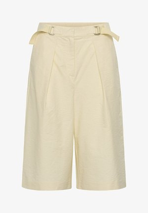 Roomkleurige, op maat gemaakte shorts met plooien aan de voorkant en verstelbare zijriemen met metalen gespen.