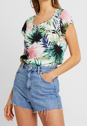 Haut à manches courtes avec un motif floral dans des teintes de vert, rose et noir ; associé à un short en denim frangé taille haute de couleur bleu clair.