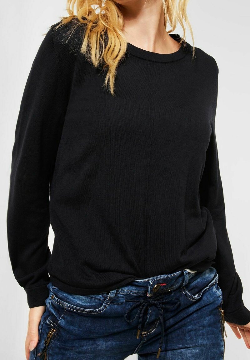 Suéter negro de manga larga con cuello redondo, fabricado en un tejido suave. Presenta un diseño ajustado y un sutil detalle de costura.