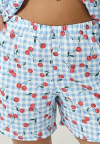 Blue and white gingham shorts featuring a cherry pattern, with elastic waistband and a relaxed fit, showing vibrant red cherries and green leaves.