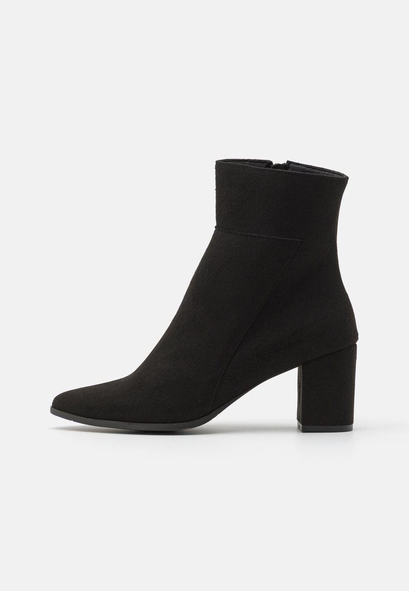 Black ankle boot made of suede, featuring a pointed toe and a block heel. Smooth texture with a side zipper closure.