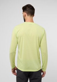 Camicia a maniche lunghe di colore verde chiaro, realizzata in tessuto morbido. Presenta un colletto rotondo e una vestibilità rilassata, con cuciture minime sul retro.