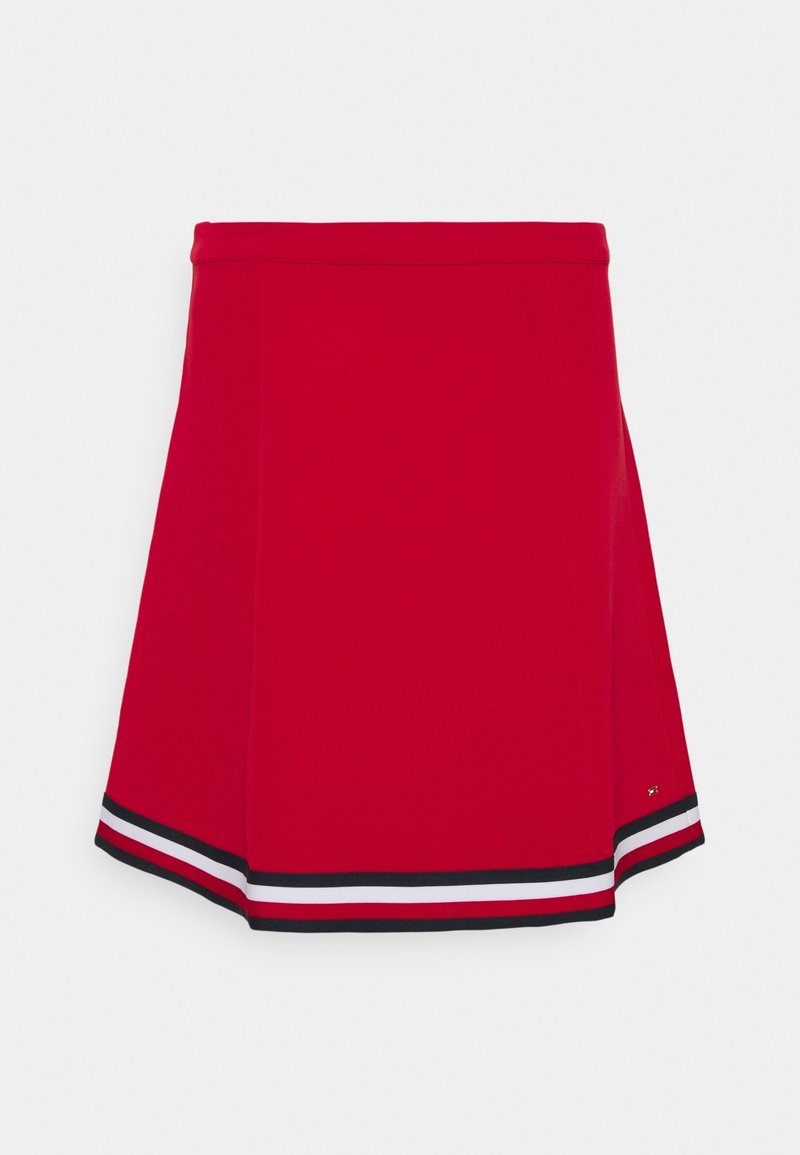 Roter Skort mit schmaler Taille und A-Linie. Hat horizontale schwarz-weiße Streifen am Saum. Glatte Stofftextur.